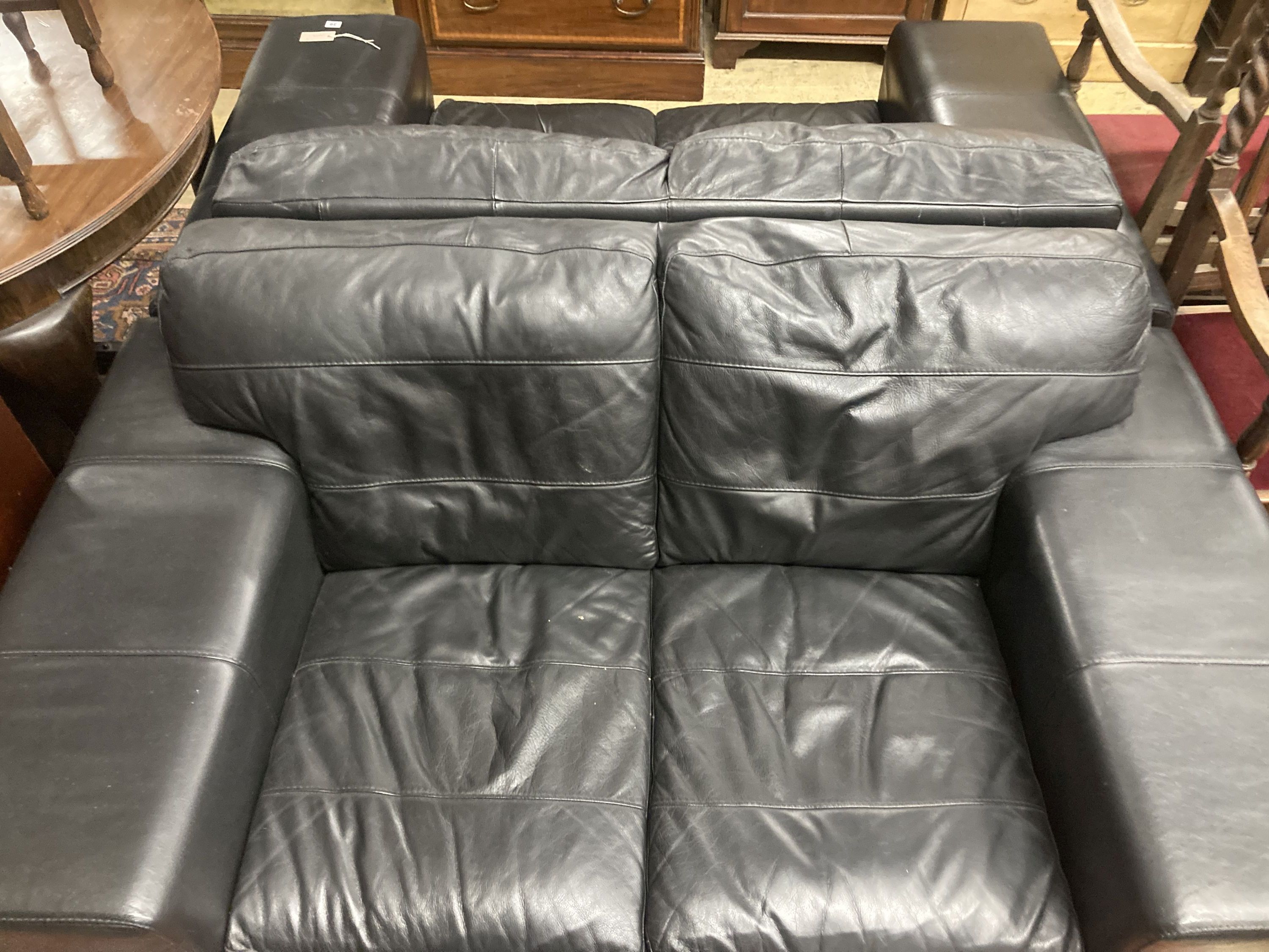 A pair of contemporary black leather two seater sofas, length 166cm, depth 92cm, height 70cm